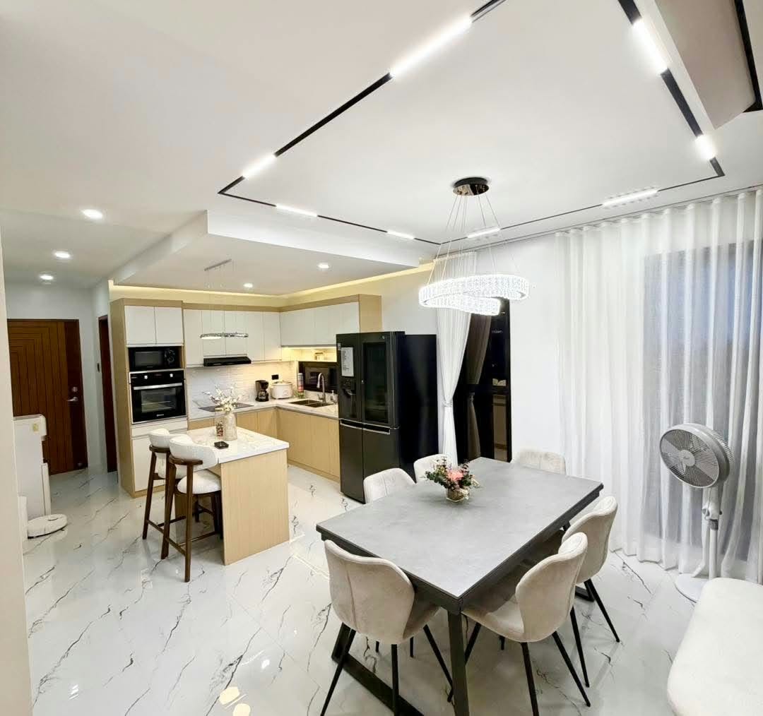 Open kitchen with cream cabinets, an island, and adjoining dining space